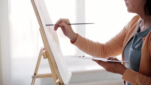 Woman Painting on Canvas in Bright Sunlight
