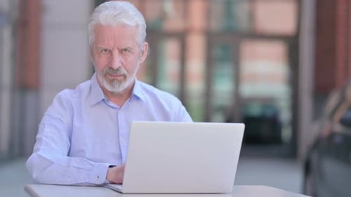 Senior Man Reacts to Something on Laptop