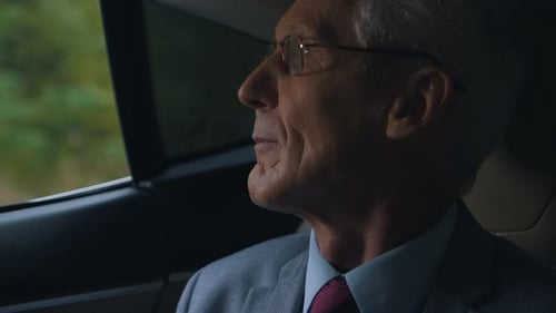 Man in Suit Rides in Car