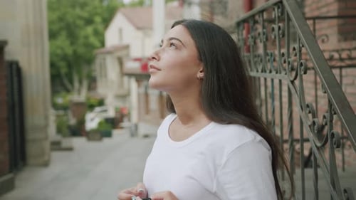 Woman Removing Face Mask on City Street