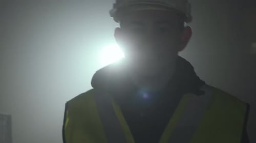 Man in Hard Hat and Safety Vest Looks On