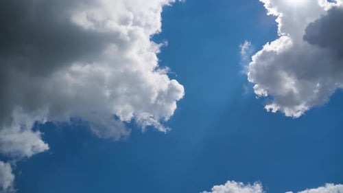 Fluffy White Clouds Moving Across a Clear Blue Sky