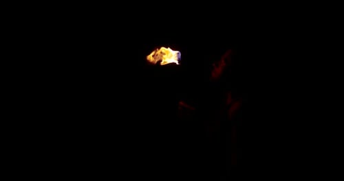 Fire Breather Spits Flame Outdoors at Night