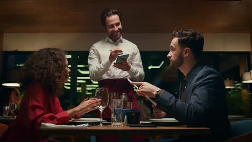 Smiling Waiter Serving Couple on Restaurant Date