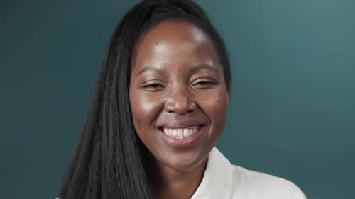 Black Female with Long Hair Posing Over Green Studio Background Smiling