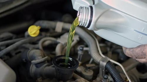 Gießen Sie frisches neues Öl in den Automotor in der Werkstatt