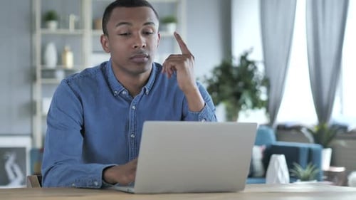 Young Adult Working on Laptop in Home Office