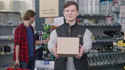Salesman Presents Box in Hardware Store