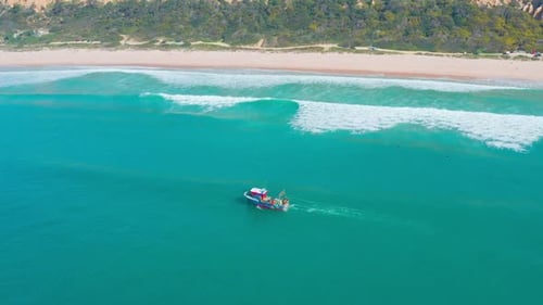 Fischerboot schwimmt auf Meereswellen in Ufernähe