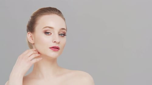 Studio portrait of young, beautiful and natural woman over grey background.