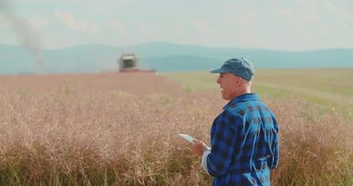 Farmer Using Digital Tablet While Examining Field