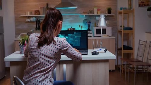 Woman Working on Laptop in Modern Kitchen