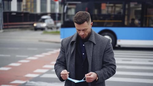 Cara com máscara médica ao ar livre. Jovem empresário em uma caminhada casual inteligente durante a pandemia