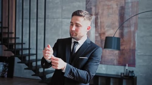 Man in Suit Adjusting Cuff Links Indoors