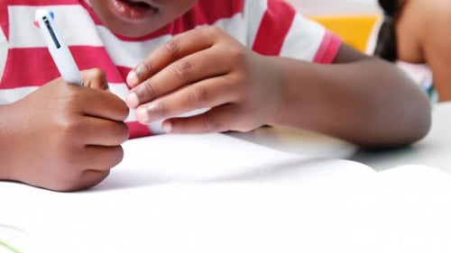 Child Writing in a School Classroom Close Up