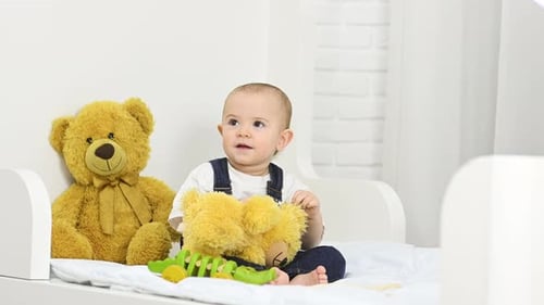 Cute Baby Playing with Toys on Bed