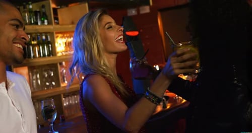 Friends Embrace While Drinking at Bar at Night