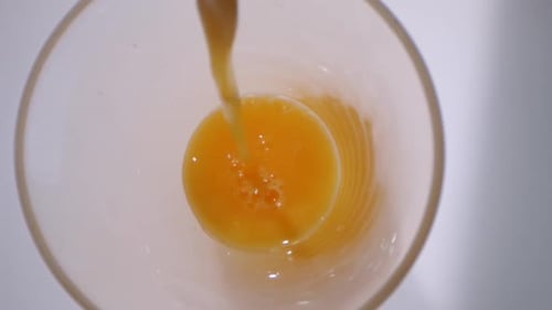 Bright Orange Juice Being Poured Into Clear Glass
