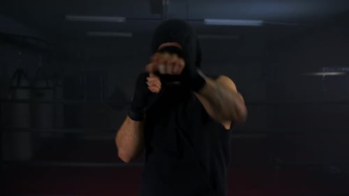 Boxer Shadow Boxing in a Dark Gym