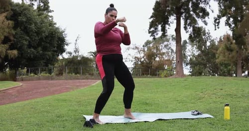 Curvy woman doing boxing exercises at park - Sport and workout concept