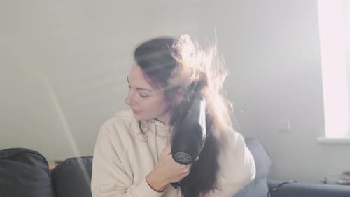Woman Drying Her Wavy Hair With a Hairdryer