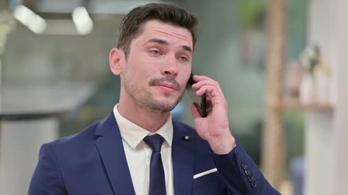 Man in Suit Talking on Smartphone Indoors