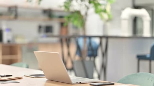 Young Adult Types at Laptop in Modern Office