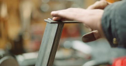 Adult Filing Metal Bar in Workshop Close Up