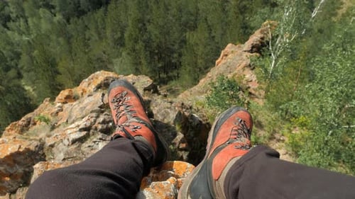 Sitting on the Edge of a Mountain Cliff