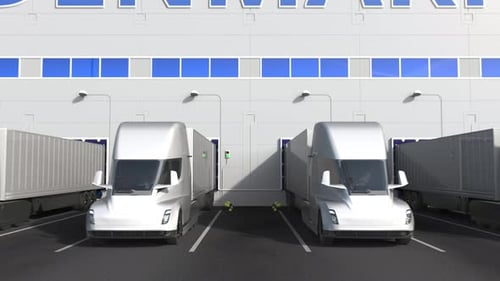 Electric Trailer Trucks at Warehouse with PRODUCT OF DENMARK Text