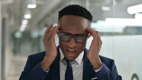 Man Suffering Headache in Bright Office Environment