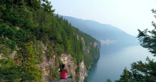 Woman performing yoga on top of a mountain 4k