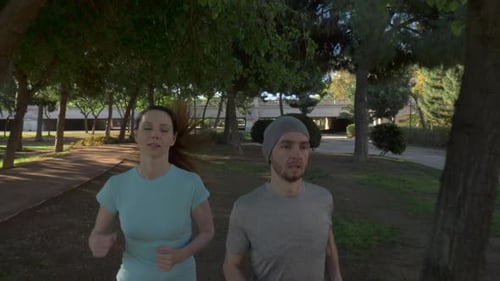 Athletic Couple Jogging Through Urban Park