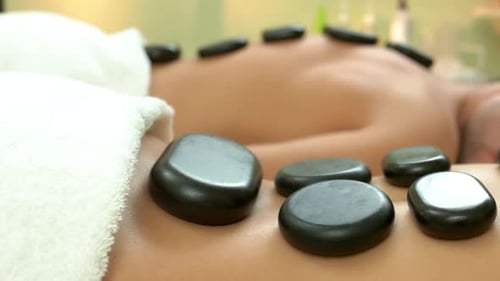 Close Up of Female Body with a Lot of Black Stones
