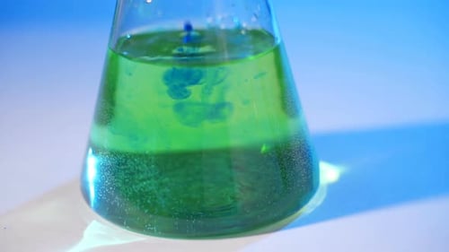 Adding Blue Liquid to a Green Beaker