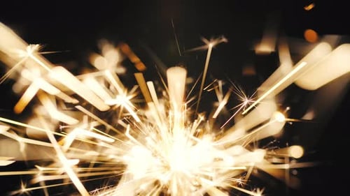 Sparkler Burning Brightly with Golden Sparks in the Dark