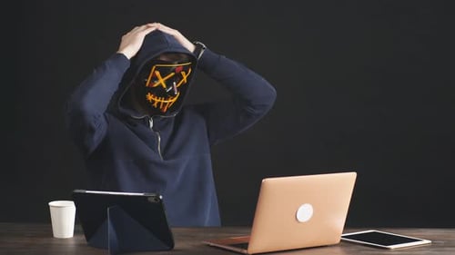 Hooded Figure Wearing Mask Types Frantically