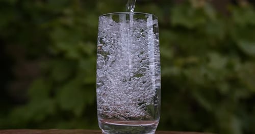 900112 Wasser wird in Glas gegossen, Zeitlupe 4K