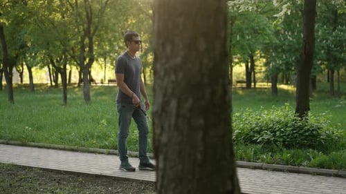 Blinder Mann geht mit einem Stock im Park