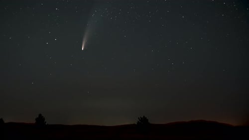 Brilliant Comet Streaking Through Starry Night Sky