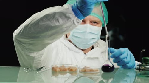 Scientist Drips Purple Liquid onto Meat in Lab