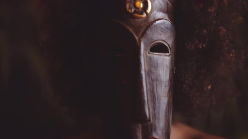 Woman With Afro Holding Traditional Mask Over Face