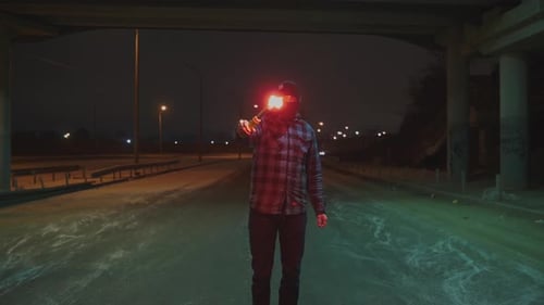 Man in Balaclava with Red Burning Signal Flare at Night