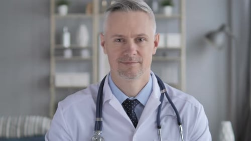 Friendly Doctor Waving and Speaking to Camera