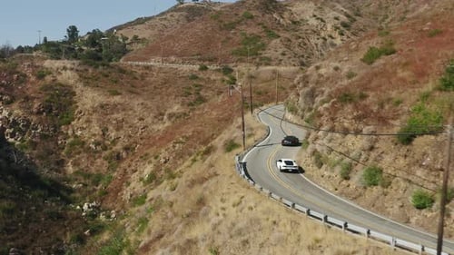 Black and White Exotic Sports Car Driving By Winding Road in Malibu Canyon