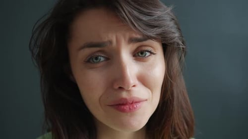 Close-up Portrait of Unhappy Young Woman Crying Feeling Sad on Dark Background