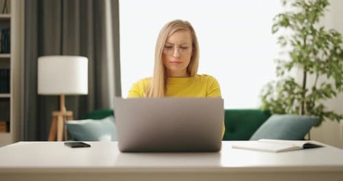 Woman Working on Laptop at Home at Desk