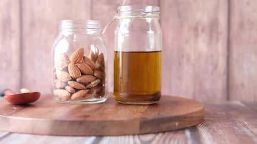 Almond Oil in Bottle on Wooden Background