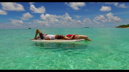 Young couple suntan on tropical resort beach time by blue green ocean and white sand background of t