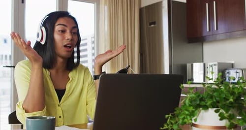 Young Adult Communicates Remotely with Laptop at Home